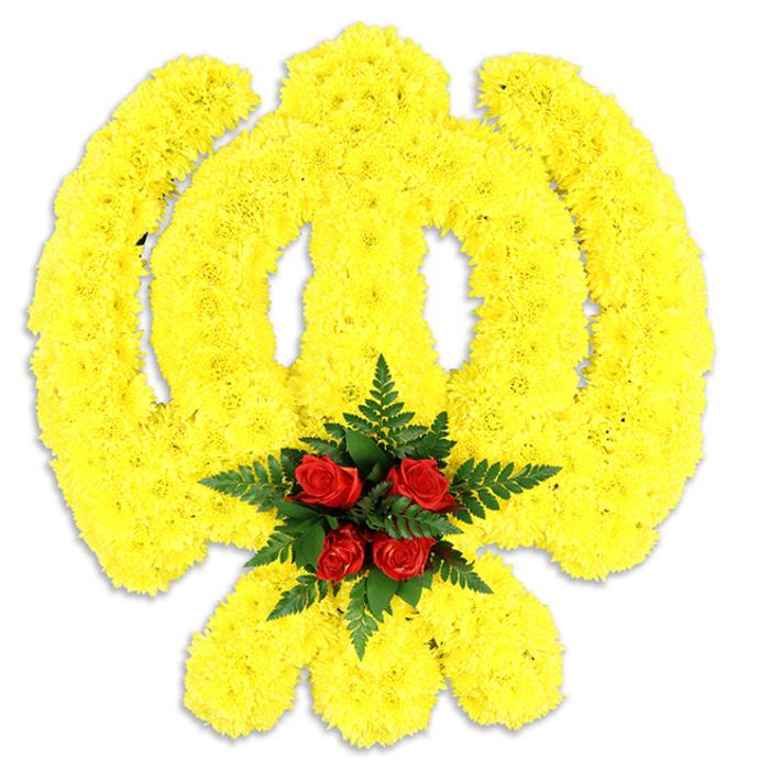 A large, reverent Khanda motif is meticulously sculpted from a dense field of bright yellow chrysanthemums that together form the circular chakkar, the upright double-edged khanda, and the two crossed kirpans below. Photographed against a clean white background, the yellow blooms are packed so closely that their petals create a gently undulating surface, giving the emblem a soft, tactile relief and a subtle three-dimensional profile. Anchoring the design is a concentrated cluster of five to six deep red roses at the emblem's centre, their velvety petals folding inward and held in a nest of dark green fern fronds; the ferns' fine texture and cool tone frame the roses and intensify the crimson focal point against the surrounding yellow. A soft grey shadow beneath the arrangement suggests it is a substantial physical tribute-likely a funeral wreath or ceremonial centerpiece-set in gentle studio light that enhances colour saturation without flattening detail. The piece reads as an offering of both beauty and cultural respect, crafted with the kind of attention local families expect in North London. At Flower Delivery New Southgate we frequently prepare floral emblems like this for memorial services and religious commemorations in the area, including communities around Brunswick Park, Arnos Grove and Palmers Green, where the combination of colour, scent and texture carries quiet meaning.