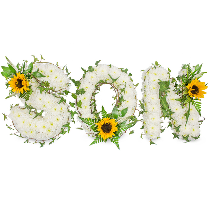 A three-dimensional, personalized floral piece spells out SON in capital letters, each letter densely covered with small, immaculate white chrysanthemums, giving the surface a pillowy, textured depth that catches the eye. Interspersed among the white blooms are rich green elements: trailing ivy vines with their distinctive lobed leaves wrap through and around all three letters, while soft fern fronds and pointed leafy sprigs add layers of contrast and natural definition. Strategically placed to draw the gaze, three bright sunflowers introduce golden warmth - one seated on the upper left curve of the S, one resting at the lower curve of the O amid lush greenery, and one adorning the upper right shoulder of the N - each sunflower offering a radiant halo of yellow petals around a pronounced dark brown center. Photographed on a clean white background under soft, neutral studio lighting, the arrangement's tactile contrasts are clear: the chrysanthemums' dense clouds, the sunflower centers' textured disks, and the glossy, sculptural ivy. As an experienced florist serving families across New Southgate, Arnos Grove, and the nearby streets off Friern Barnet Road, I design these word tributes as respectful, bespoke commemorations for funeral services and memorial displays. The harmony of pure white, deep green, and sunflower yellow communicates peaceful remembrance and a hopeful light - a composed, heartfelt way to honour the memory of a beloved son.