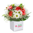 There's an uplifting spirit flowing through this meticulously crafted bouquet-a reflection of New Southgate's friendly character. The arrangement features lush coral and peach carnations, each petal finely ruffled and soft to the touch, releasing a subtle fragrance that conjures memories of tranquil afternoons by Arnos Grove. White daisies, with their glowing golden-green centers, add lightness and cheer, while clouds of baby's breath dance delicately between them, creating a dreamy, innocent effect. Deep green, glossy leaves cradle the blooms, forming a graceful arc at the base, reminiscent of strolls past the leafy streets of Friern Barnet. Peeking through are hints of purple-tipped buds promising future blossoms, their closed shapes adding anticipation and depth. The ensemble stands proudly in a crisp white gift bag with ribboned handles-perfectly arranged for a heartfelt delivery to brighten someone's special occasion or offer comfort in New Southgate. Every detail, from the careful placement of stems to the play of colours and textures, speaks of thoughtful floristry and genuine care. This bouquet is not just a collection of flowers but an invitation to celebrate, reflect, and share a piece of New Southgate's everyday beauty, delivered fresh to your door.